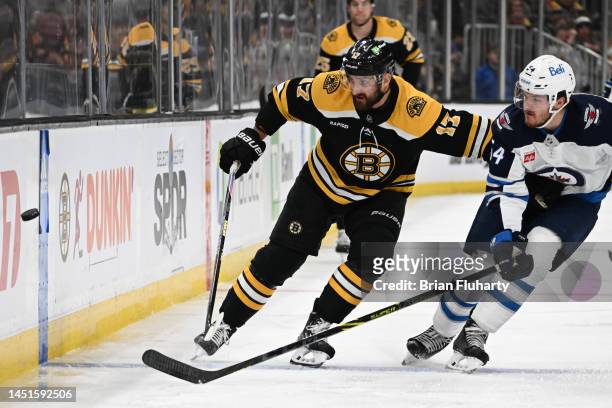 Nick Foligno of the Boston Bruins and Dylan Samberg of the Winnipeg Jets battle for the puck during the first period at the TD Garden on December 22,...