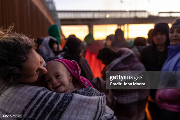 Venezuelan immigrant Stephanie holds her daughter Hannie, 10 months, after spending the night camped alongside the U.S.-Mexico border fence on...