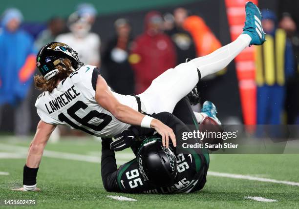 Trevor Lawrence of the Jacksonville Jaguars loses the ball as he is sacked by Quinnen Williams of the New York Jets during the 1st quarter of the...