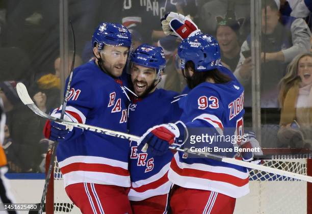 Vincent Trocheck of the New York Rangers celebrates his empty net goal against the New York Islanders and is joined by Barclay Goodrow and Mika...