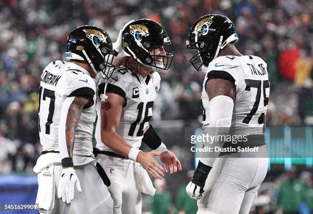 Trevor Lawrence of the Jacksonville Jaguars celebrates with Evan Engram and Jawaan Taylor after a touchdown during the 1st half of the game at...