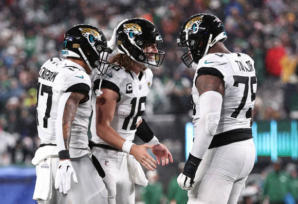 Trevor Lawrence of the Jacksonville Jaguars celebrates with Evan Engram and Jawaan Taylor after a touchdown during the 1st half of the game at...