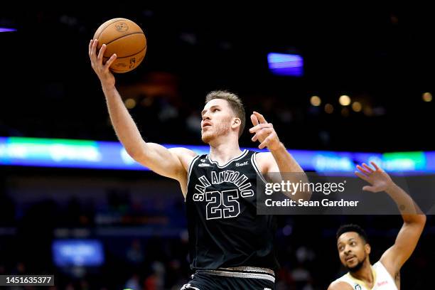 Jakob Poeltl of the San Antonio Spurs shoots over CJ McCollum of the New Orleans Pelicans during the third quarter of an NBA game at Smoothie King...