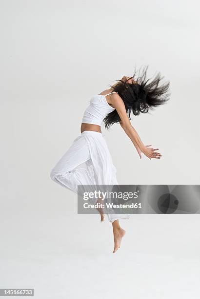 young woman jumping and dancing - white people dancing stock pictures, royalty-free photos & images