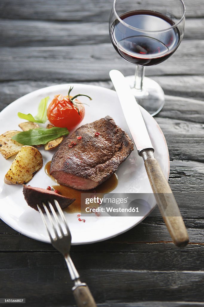 Germany, Bremen, Steak with vegetable and wine on table
