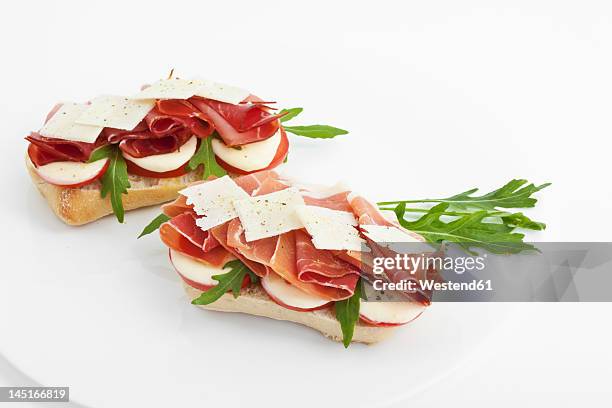 panini with ham, tomatoes, mozarella, rocket and italian cheese in plate - roquette photos et images de collection