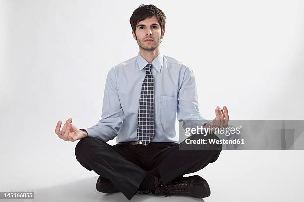 businessman doing meditation, portrait - schneidersitz stock-fotos und bilder