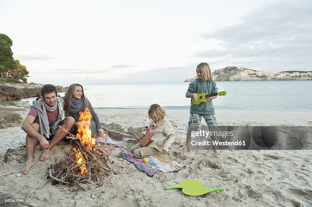Spain, Mallorca, Friends at camp fire on beach