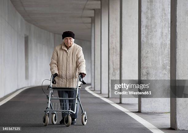 austria, senior woman with wheeled walker at subway - walking frame stock pictures, royalty-free photos & images