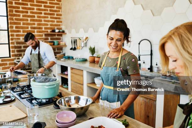 medium shot of chef watching students prepare dishes during cooking class - 40 49 years stock pictures, royalty-free photos & images