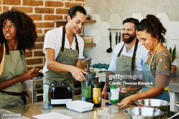 medium shot of students laughing with female chef during cooking class - mexico black and white stock-fotos und bilder