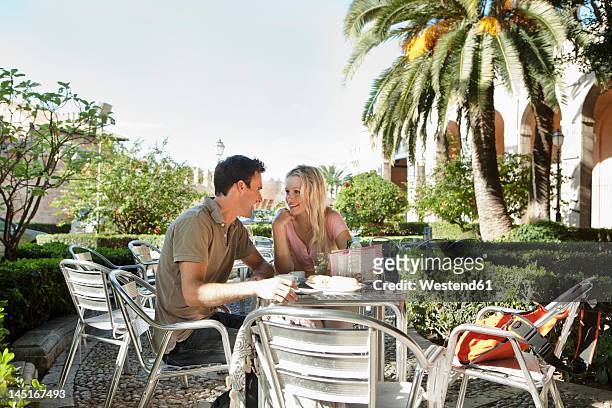 spain, mallorca, palma, couple sitting at table in cafe, smiling - palma stock-fotos und bilder