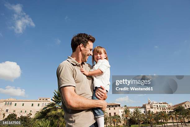 spain, mallorca, palma, father carrying daughter, smiling - palma mallorca stock-fotos und bilder