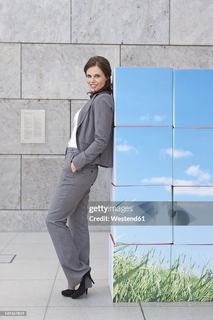 Germany, Leipzig, Businesswoman with cubes, smiling, portrait
