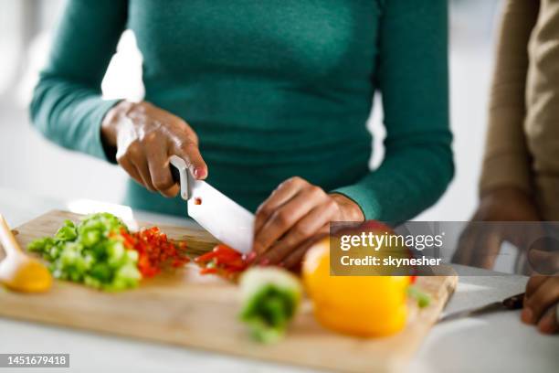 close up of a black woman cutting bell peppers. - chopping 個照片及圖片檔