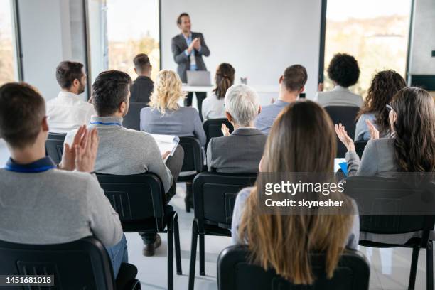 vista posteriore degli imprenditori che applaudono sull'evento educativo in sala riunioni. - studio foto e immagini stock