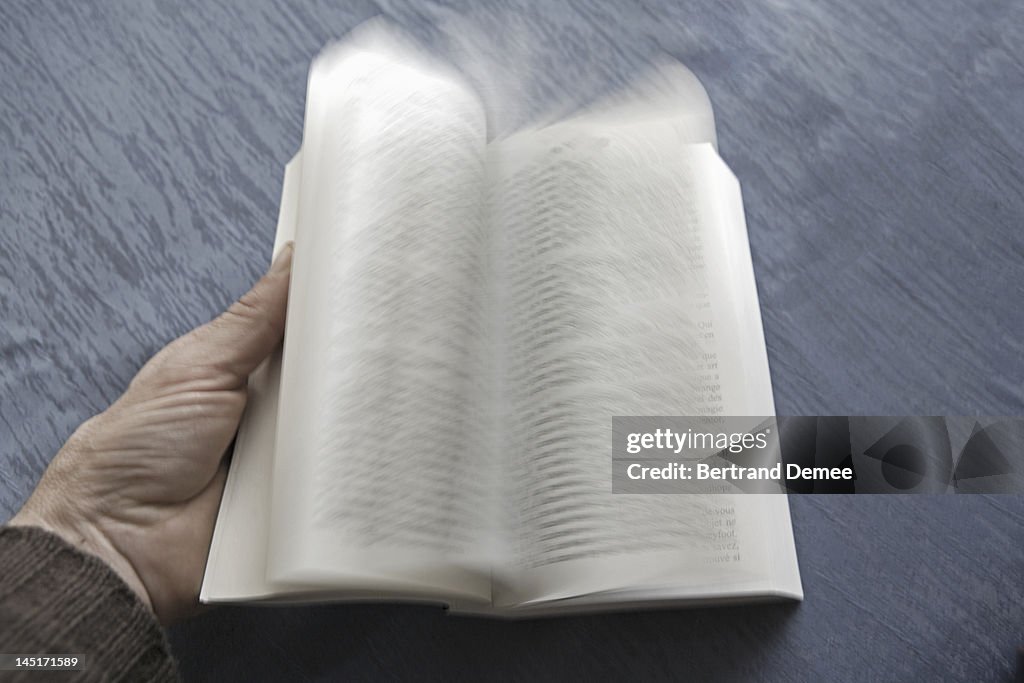 Open book with pages turning, blurred motion