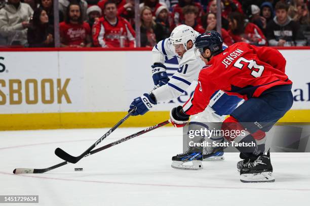 John Tavares of the Toronto Maple Leafs skates with the puck as Nick Jensen of the Washington Capitals defends during the first period of the game at...