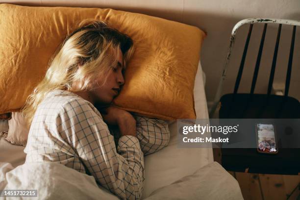 side view of transgender person sleeping on bed at home - acostado de lado fotografías e imágenes de stock