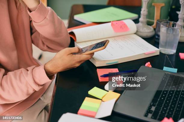 midsection of transgender person using smart phone while studying at home - nb stock pictures, royalty-free photos & images