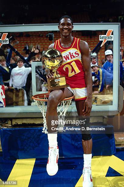 Doninique Wilkins of the Atlanta Hawks poses on top of the basket with the Slam Dunk Champion Trophy after wining the contest during the NBA All Star...