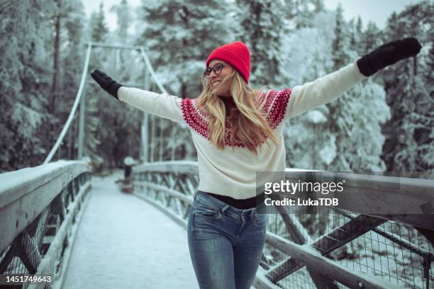 happy woman dancing on the bridge during a snowy day - finland happy stock pictures, royalty-free photos & images