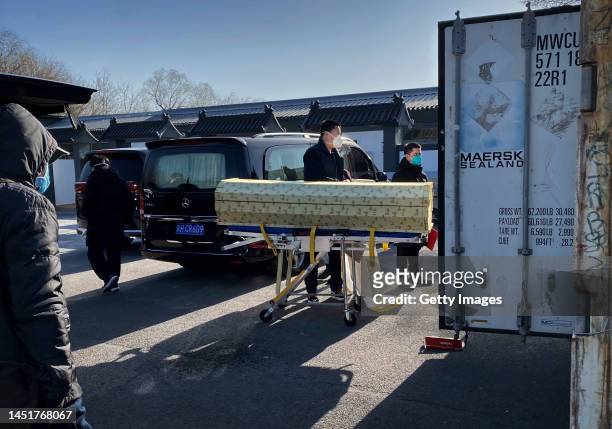 Coffin is loaded from a hearse into a storage container at the Dongjiao crematorium and funeral home, one of several in the city that handles...