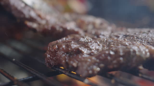 Turning Meat Steaks on BBQ Grill