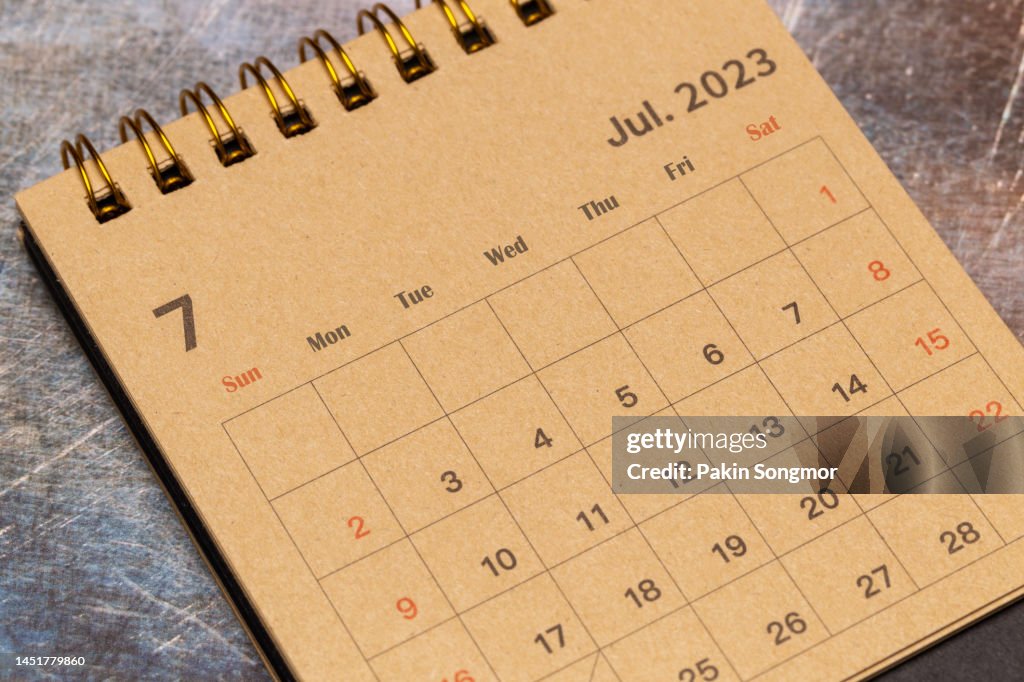 Calendar desk 2023: July is the month for the organizer to plan and deadline with a grunge paper background.