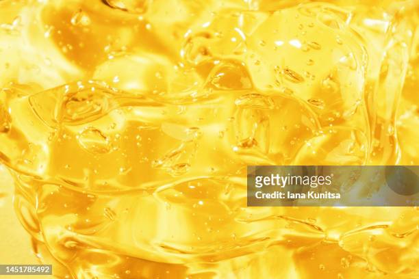 transparent yellow smudged texture. vitamin c. facial serum. antibacterial gel with bubbles. cosmetic products for skincare. - gelatin mold fotografías e imágenes de stock