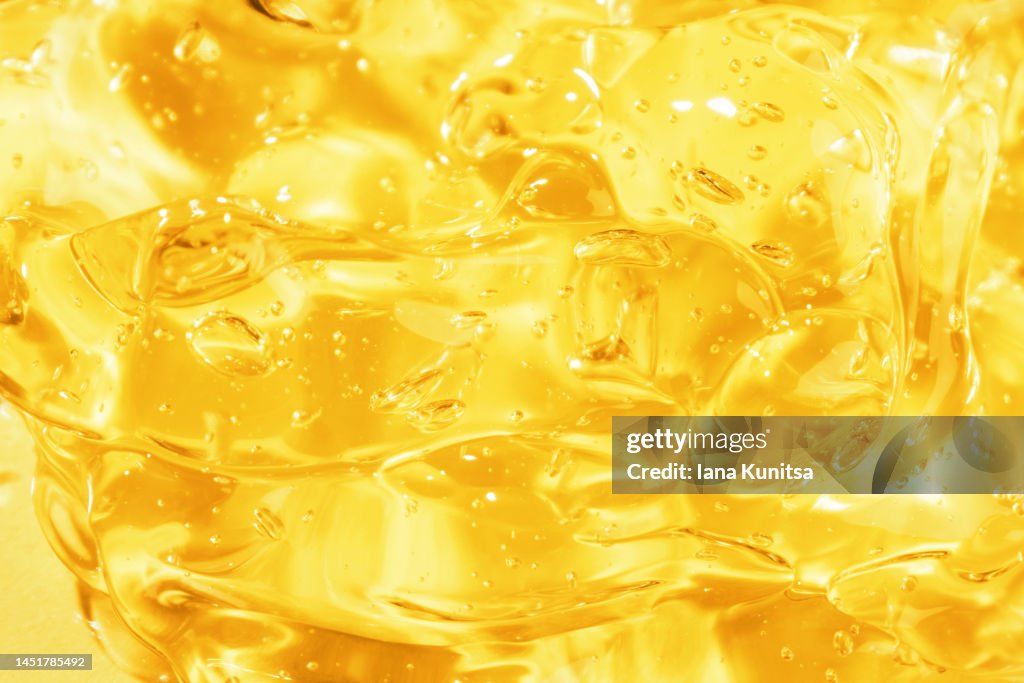 Transparent yellow smudged texture. Vitamin C. Facial serum. Antibacterial gel with bubbles. Cosmetic products for skincare.