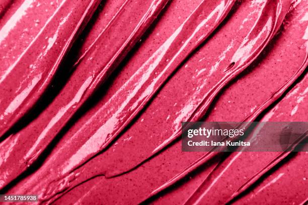 red, pink, viva magenta lipstick smears. lip gloss samples are smudged. beauty cosmetic texture. makeup and skin care products. color of the year 2023. - lip gloss smudge stock-fotos und bilder