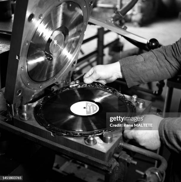 Pressage d'un disque vinyle dans une usine, dans les années 1960.