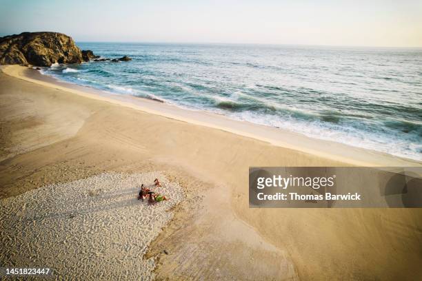 wide shot aerial view of female friends relaxing on beach at sunset - baja california sur stock pictures, royalty-free photos & images