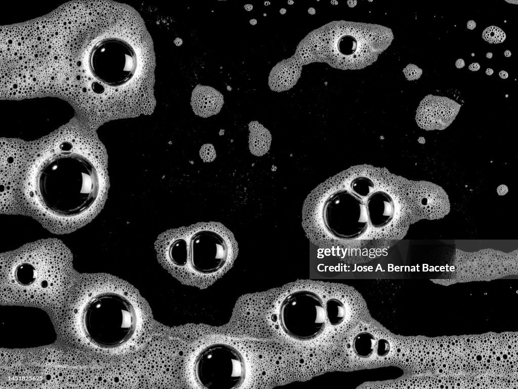 Full frame of the bubbles and soap suds in the bathroom on a black background.