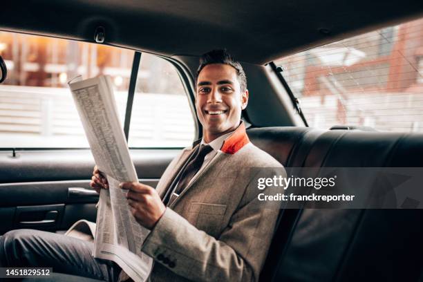 business man reading a newspaper on the taxi - man in car reading newspaper stock pictures, royalty-free photos & images