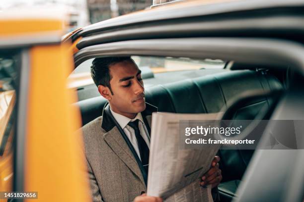 geschäftsmann liest zeitung im taxi - newspaper luxury stock-fotos und bilder