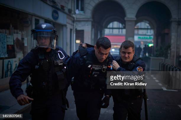 An injured French Policeman is helped away after violent clashes broke out after the visit of the French Interior Minister Gerald Darmanin to the...