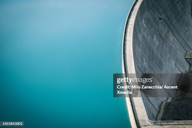 aerial view of young woman running across dam - réservoir photos et images de collection