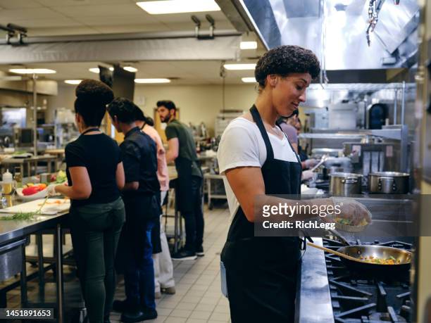 working in a commercial kitchen - catering black uniform stockfoto's en -beelden