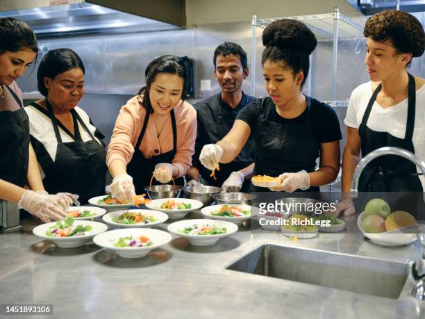 kulinarische studenten in einer großküche - kochlehrling stock-fotos und bilder