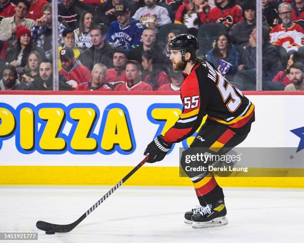 Noah Hanifin of the Calgary Flames in action against the Vancouver Canucks during an NHL game at Scotiabank Saddledome on December 14, 2022 in...