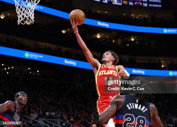 Trae Young of the Atlanta Hawks drives against Isaiah Stewart and Jalen Duren of the Detroit Pistons during the third quarter at State Farm Arena on...