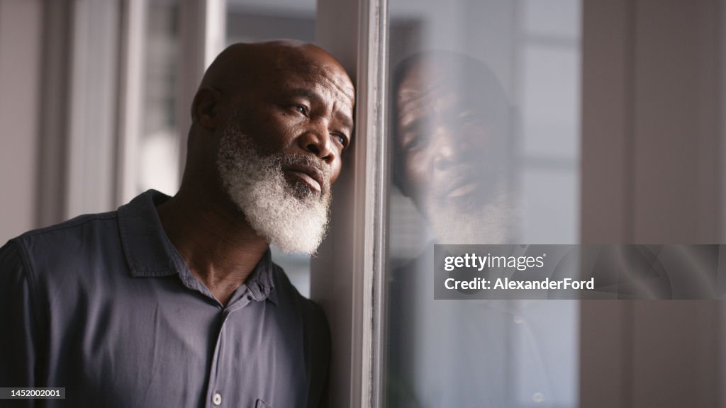 Triste, depressão ou homem negro esgotado na janela com saúde mental, dor de cabeça ou ansiedade em casa. Homem solitário, estressado ou deprimido pensando em problemas financeiros, conformidade com a saúde ou política financeira