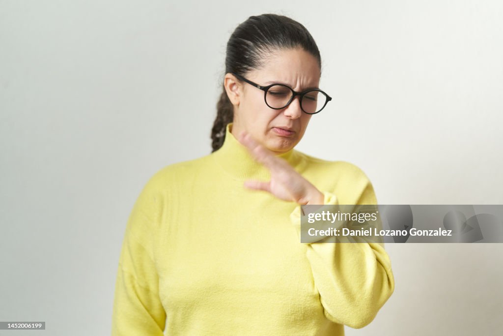 Young woman feeling disgusted and complaining while standing an isolated background.