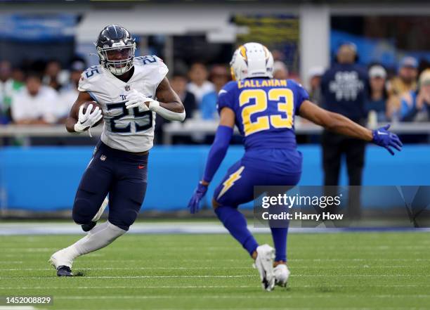 Hassan Haskins of the Tennessee Titans runs with the ball in front of Bryce Callahan of the Los Angeles ChargBryce Callahan of the Los Angeles...