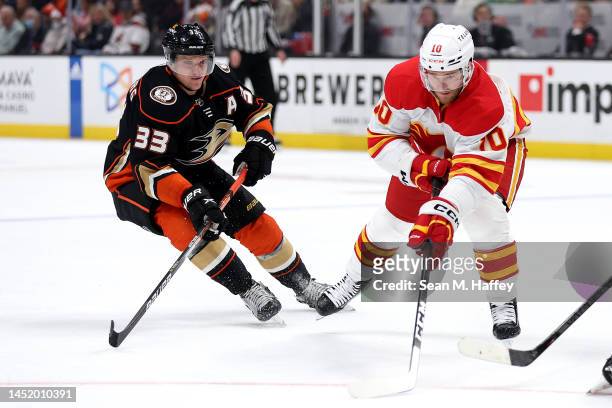 Jonathan Huberdeau of the Calgary Flames controls the puck past the defense of Jakob Silfverberg of the Anaheim Ducks during the first period of a...
