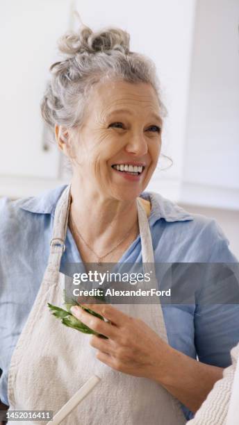 viso, sorriso e donna anziana con verdure per cucinare pasti deliziosi, gourmet o vegani. pensionamento, chef e felice donna anziana dal canada in cucina con grembiule tenendo verdure per una dieta sana - woman smile kitchen foto e immagini stock