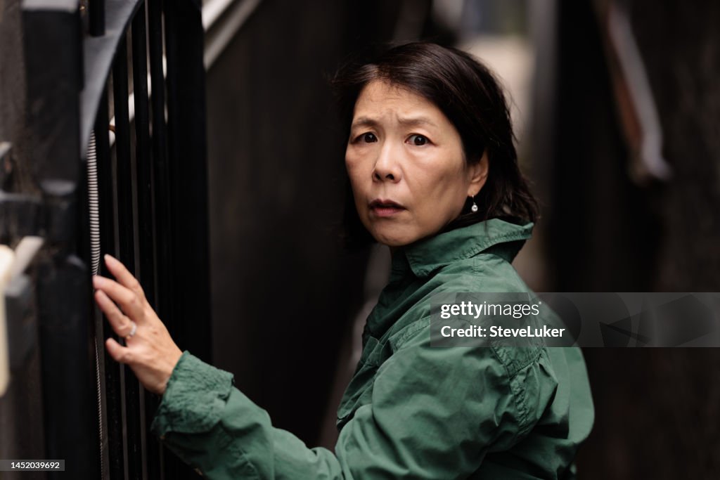 Woman looking scared in a laneway.