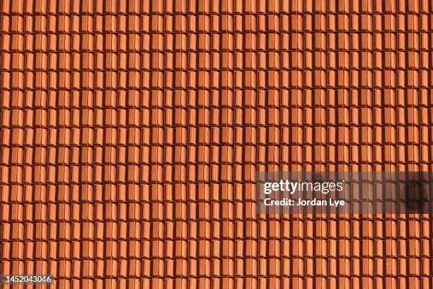 red clay roof tiles as a background - roof tile stock-fotos und bilder
